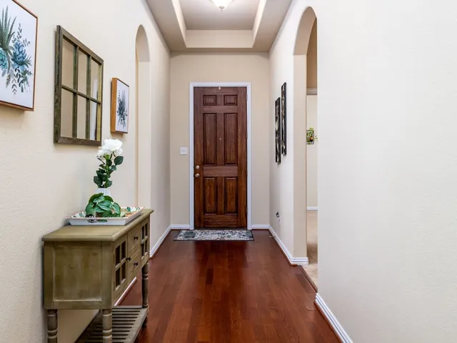 a view of a hallway with wooden floor and stairs