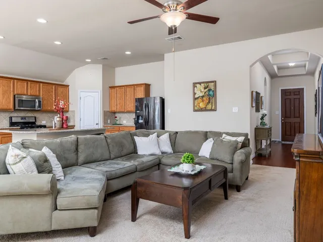 a living room with furniture and kitchen view