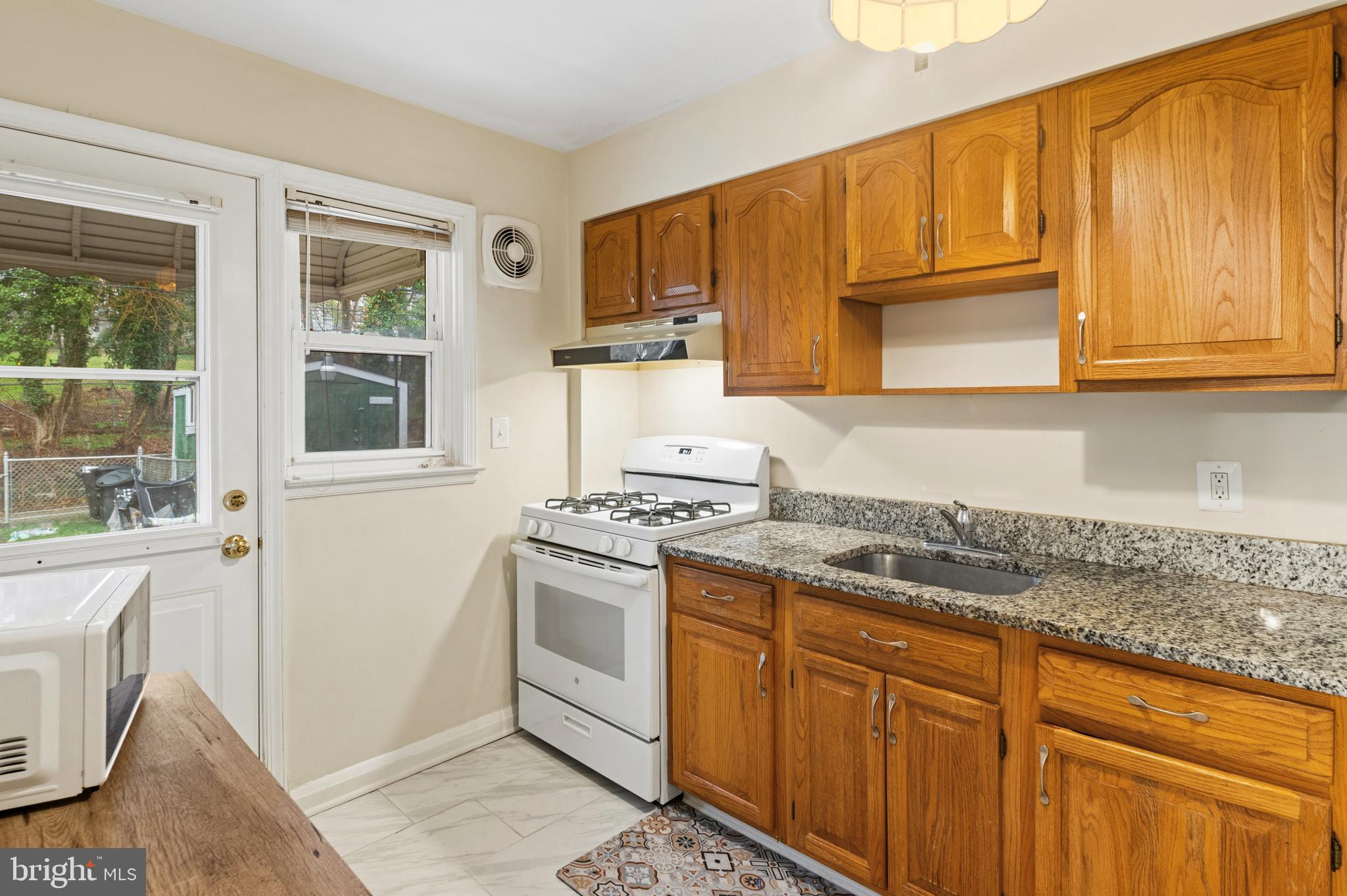 166 Cherrydell Road Baltimore, MD 21228 - Photo 13 of 24 a kitchen with stainless steel appliances granite countertop a stove a sink and a microwave