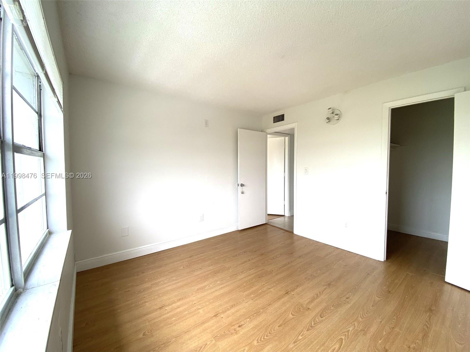 494 Northwest 165th Street, Unit C601 Miami, FL 33169 - Photo 20 of 22 an empty room with wooden floor and windows