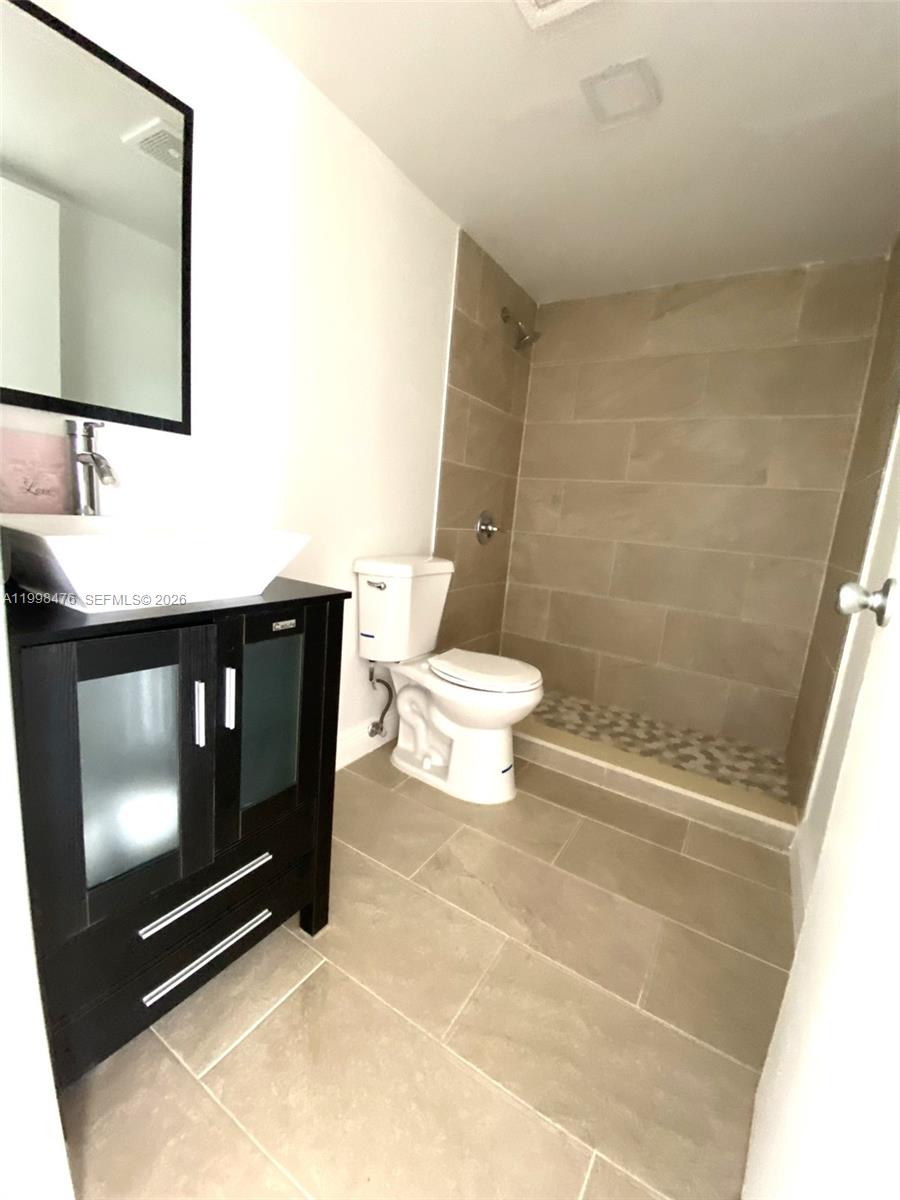 494 Northwest 165th Street, Unit C601 Miami, FL 33169 - Photo 21 of 22 a bathroom with a toilet a sink and mirror