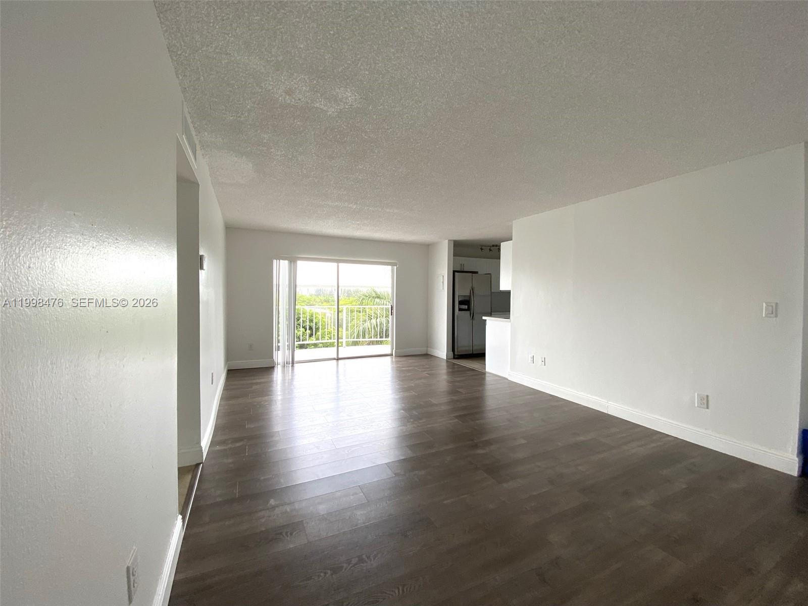 494 Northwest 165th Street, Unit C601 Miami, FL 33169 - Photo 6 of 22 wooden floor in an empty room with a window
