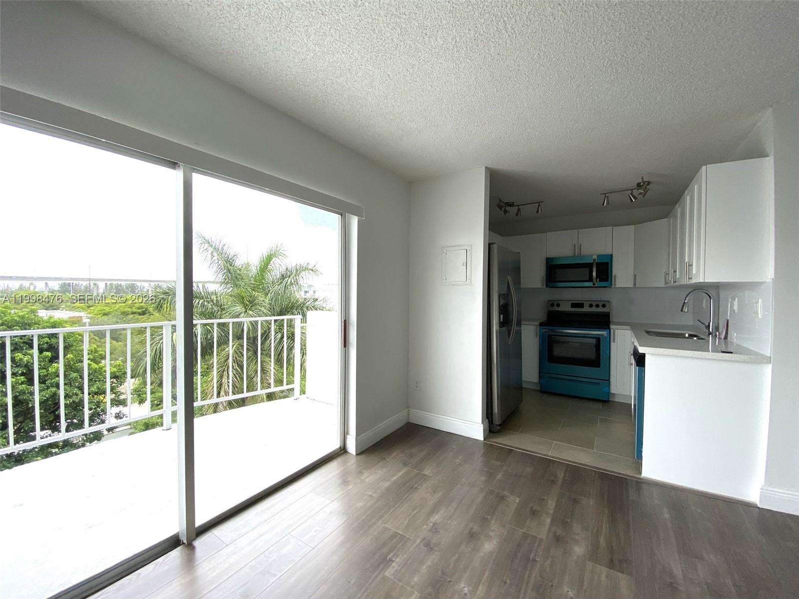 494 Northwest 165th Street, Unit C601 Miami, FL 33169 - Photo 10 of 22 a kitchen with a stove a refrigerator and a view of kitchen