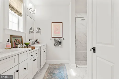 a bathroom with a granite countertop sink a mirror a vanity and a shower