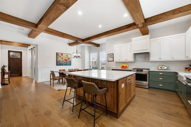 a kitchen with granite countertop white cabinets and stainless steel appliances