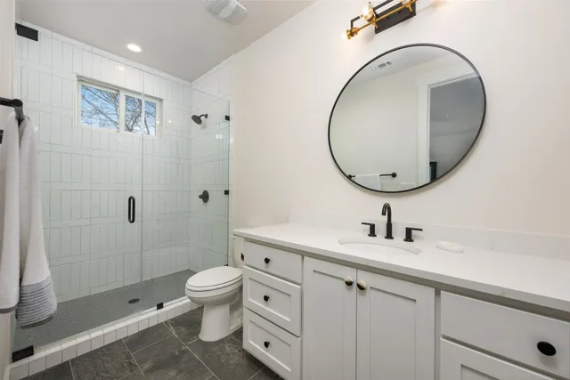 a bathroom with a shower a toilet and a sink