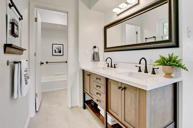 a bathroom with a double vanity sink a mirror and shower