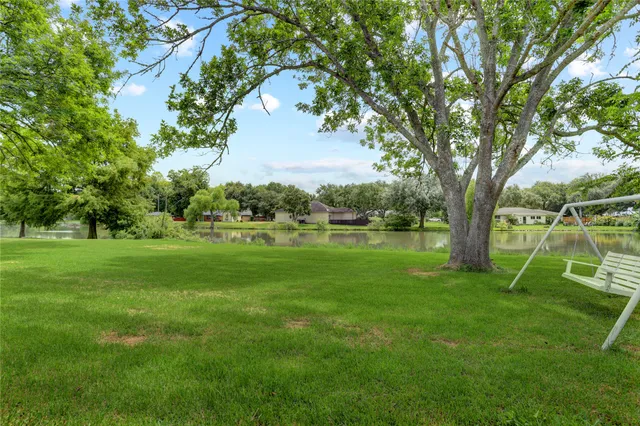 a backyard of a house with lots of green space and fountain in the back