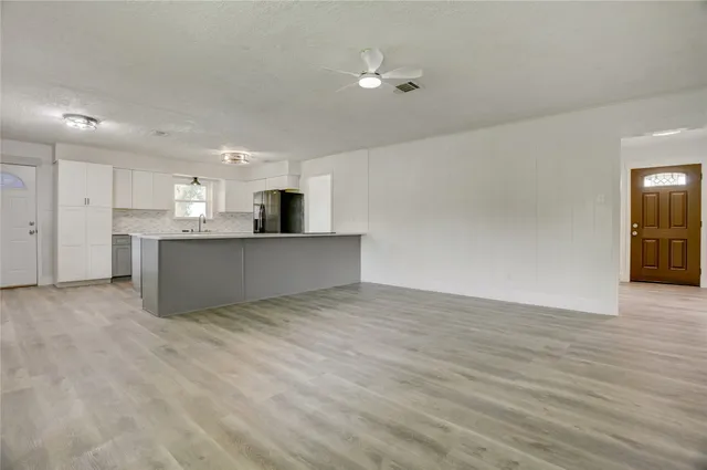 a view of a kitchen with a sink and a refrigerator