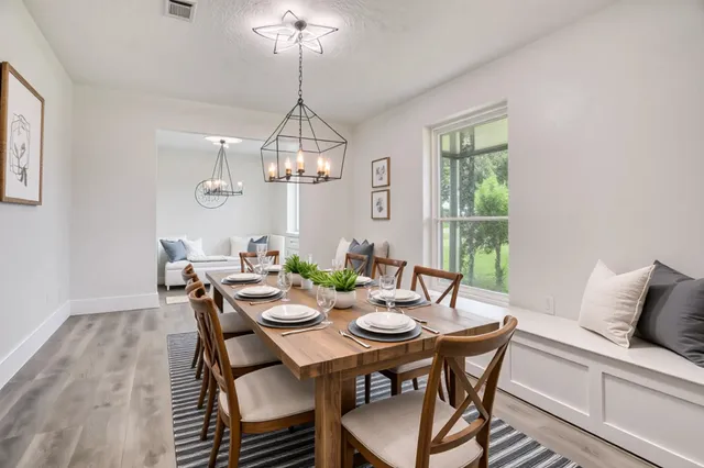 a view of a dining room with furniture wooden floor and chandelier