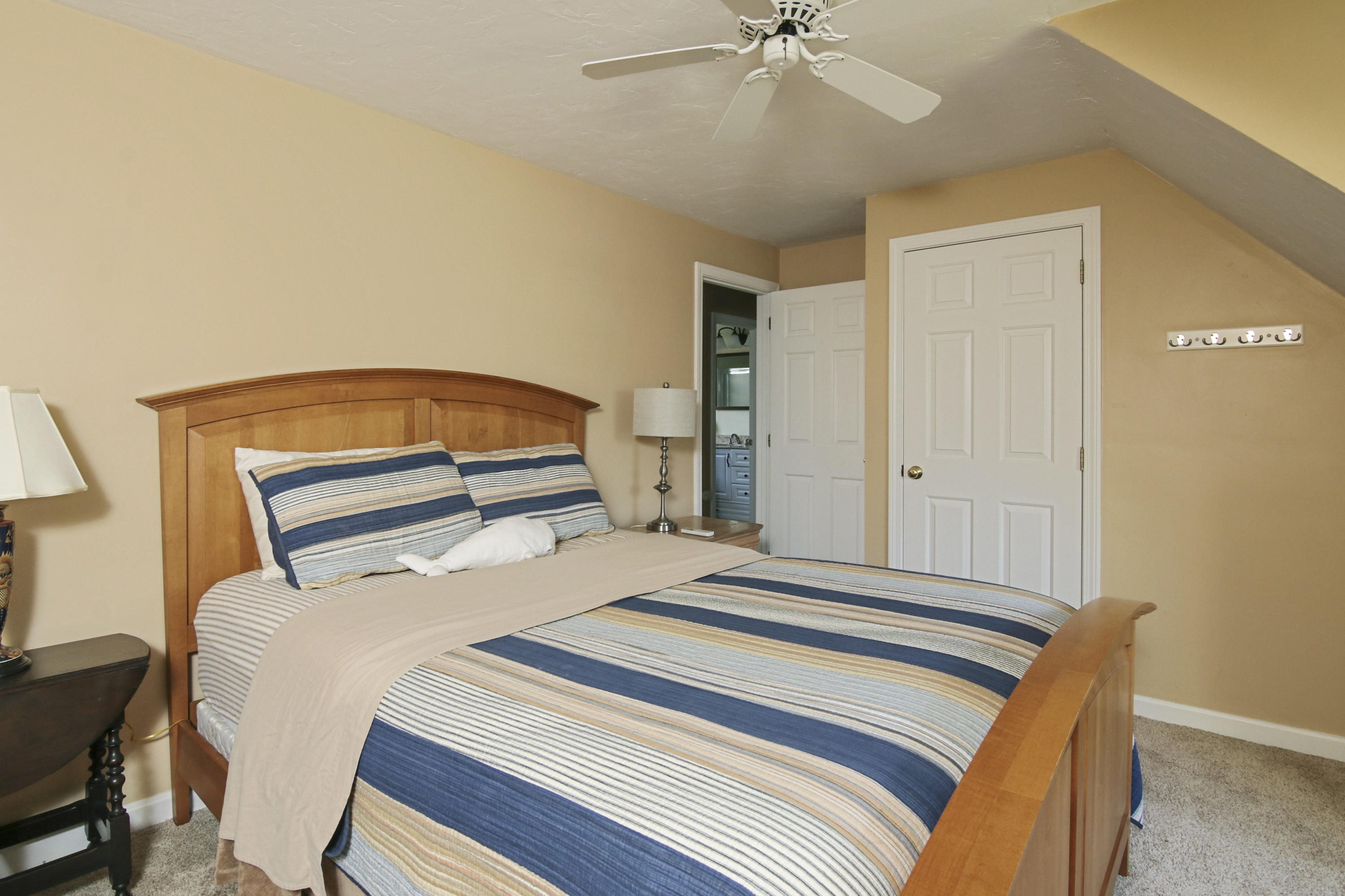 6 Hogan Drive Mashpee, MA 02649 - Photo 26 of 30 a bedroom with a bed and a chandelier