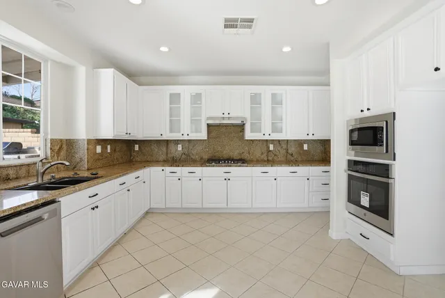 a view of a kitchen with wooden floor and electronic appliances