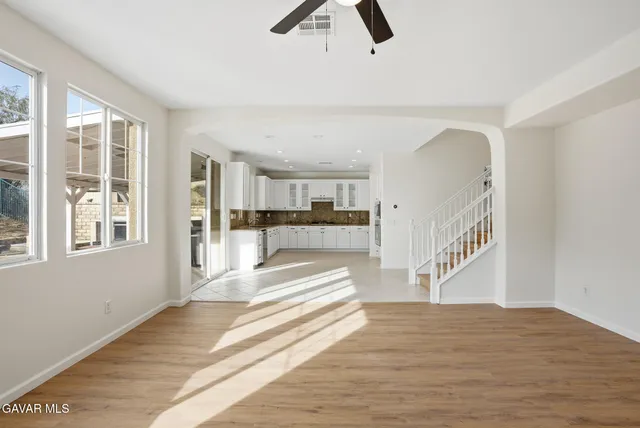 a view of a kitchen with wooden floor and a window