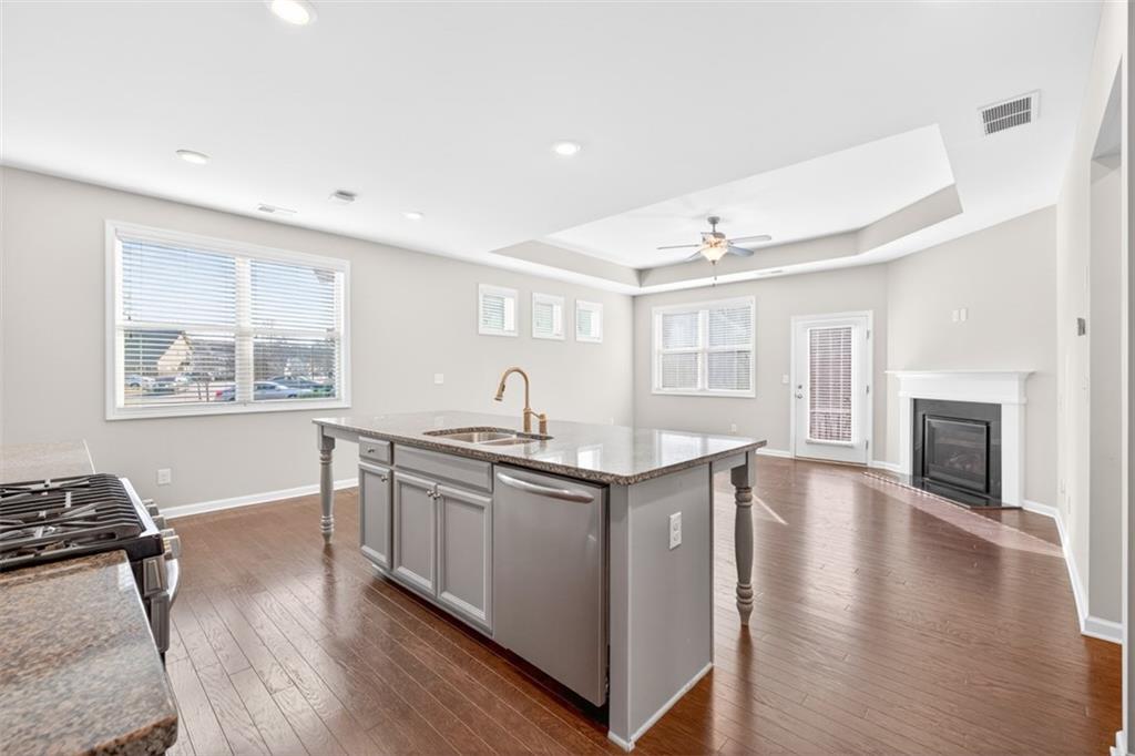 2405 Boxwalking Court Cumming, GA 30040 - Photo 12 of 54 a kitchen with stainless steel appliances granite countertop a stove and a wooden floors
