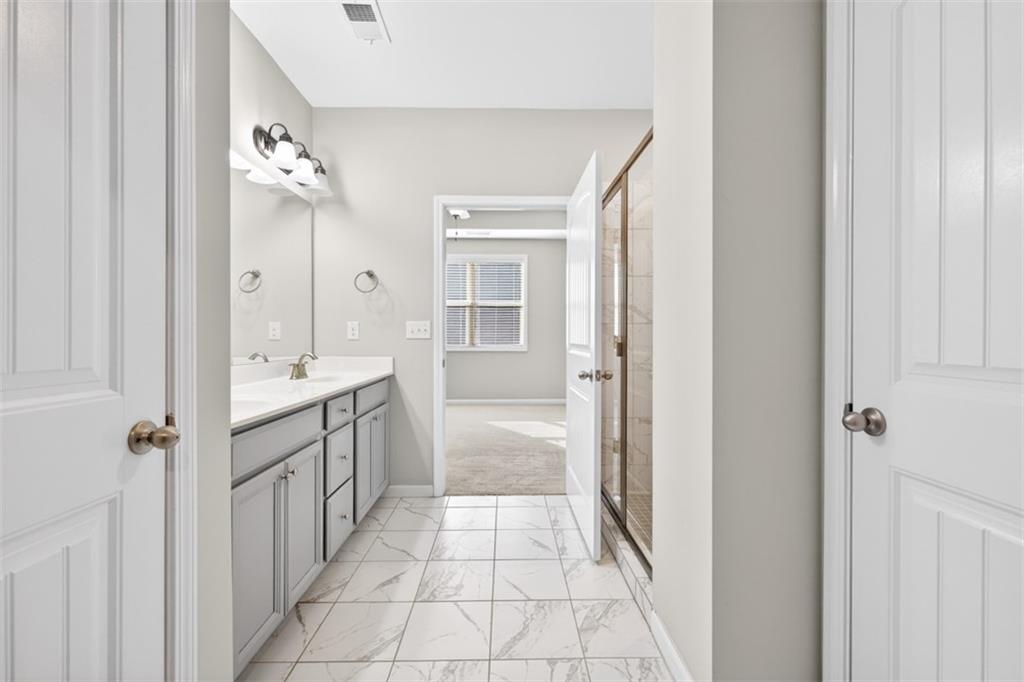 2405 Boxwalking Court Cumming, GA 30040 - Photo 27 of 54 a bathroom with a double vanity sink mirror and a bathtub