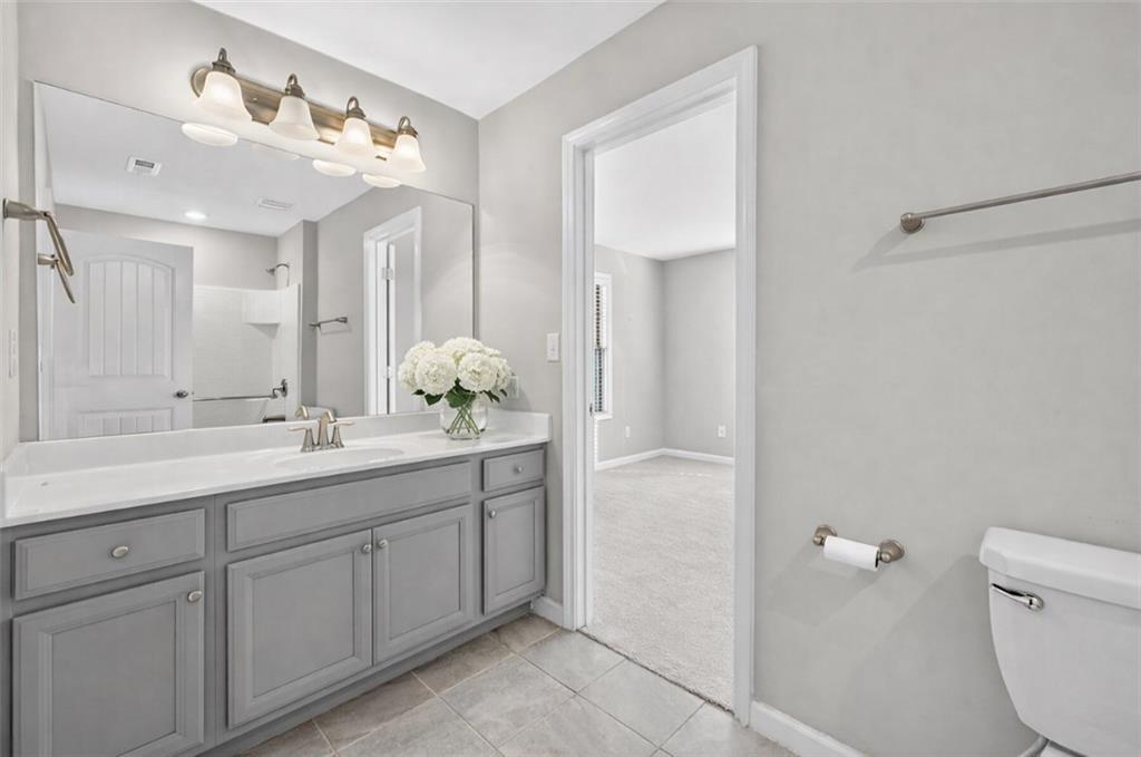 2405 Boxwalking Court Cumming, GA 30040 - Photo 32 of 54 a bathroom with a sink a toilet and a mirror