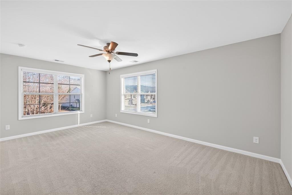 2405 Boxwalking Court Cumming, GA 30040 - Photo 36 of 54 an empty room with windows and fan