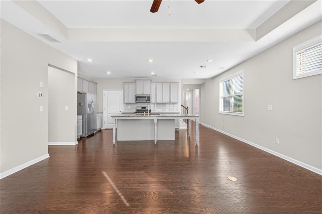2405 Boxwalking Court Cumming, GA 30040 - Photo 7 of 54 a open kitchen with white cabinets and stainless steel appliances