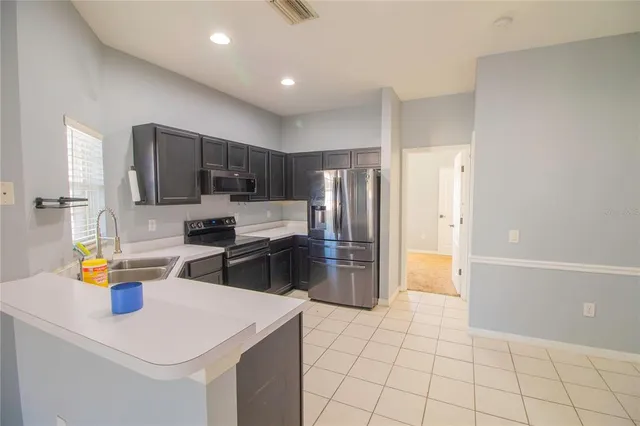 a kitchen with stainless steel appliances a refrigerator sink and microwave