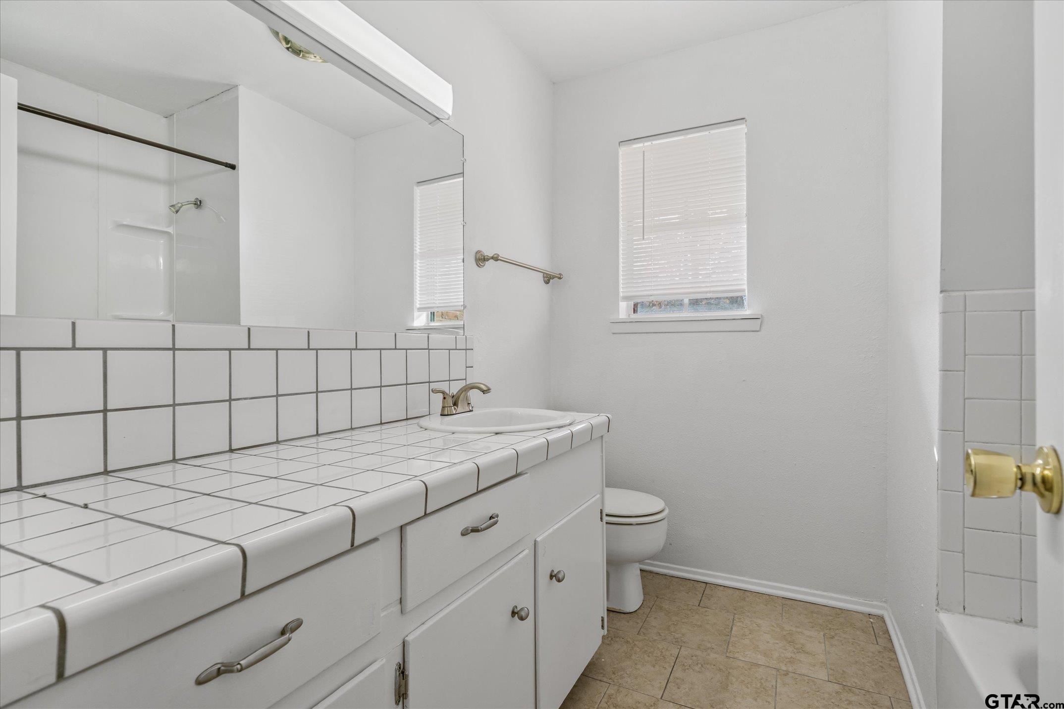 856 Ave A Canton, TX 75103 - Photo 34 of 40 a bathroom with a granite countertop sink a toilet and mirror