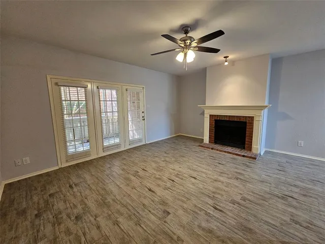 a view of empty room with wooden floor and fireplace