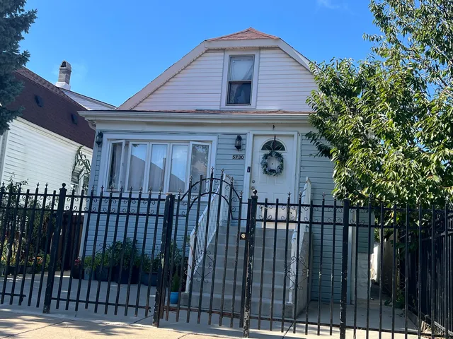 a view of a house with wooden fence