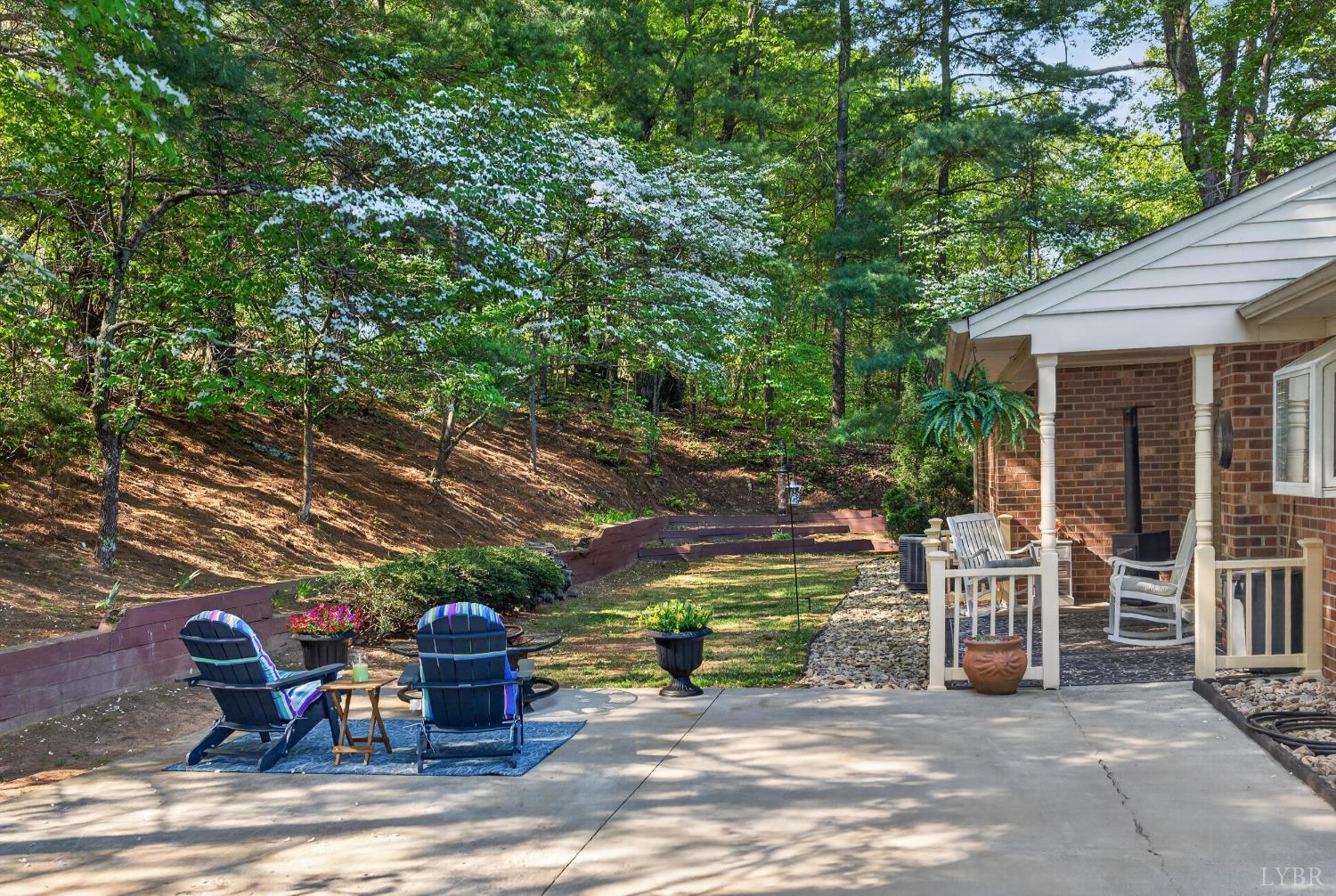 185 Clearview Circle Rustburg, VA 24588 - Photo 30 of 43 a view of a patio with table and chairs potted plants and large tree