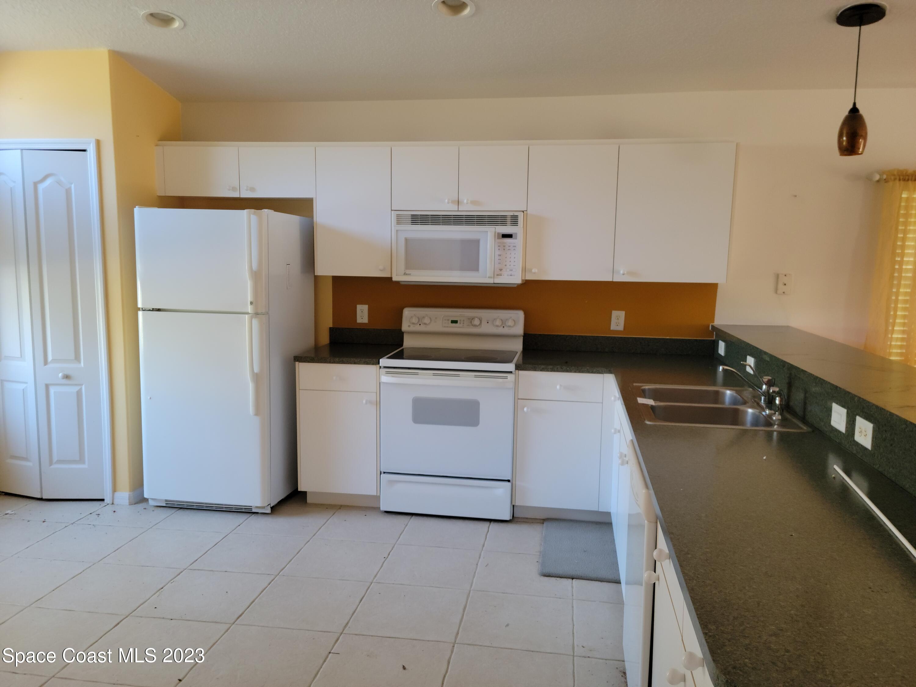 2219 Spring Creek Circle Palm Bay, FL 32905 - Photo 3 of 13 a kitchen with a stove and a refrigerator