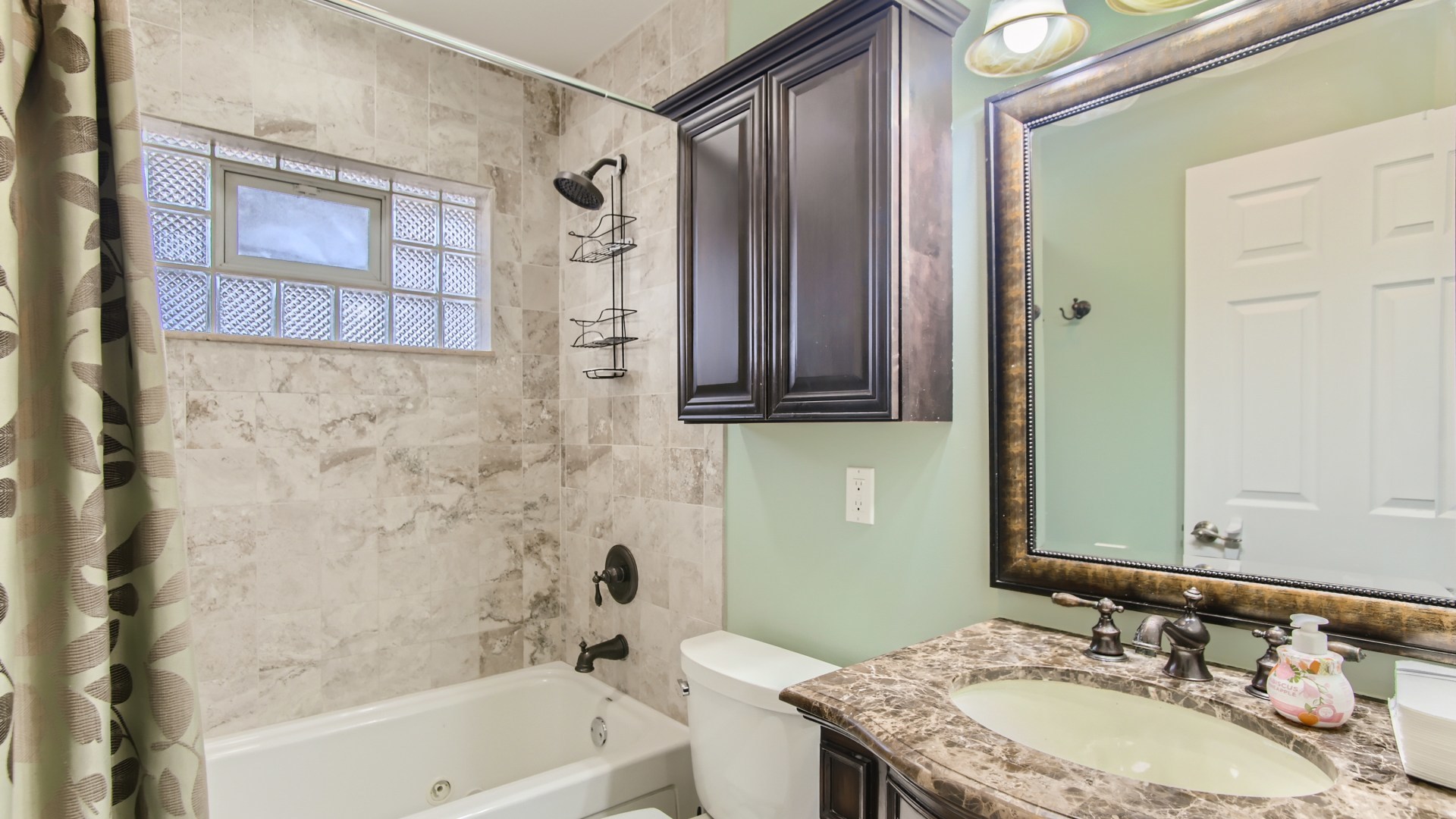 8739 West Sunset Road Niles, IL 60714 - Photo 7 of 14 a bathroom with a granite countertop sink a toilet and a bathtub