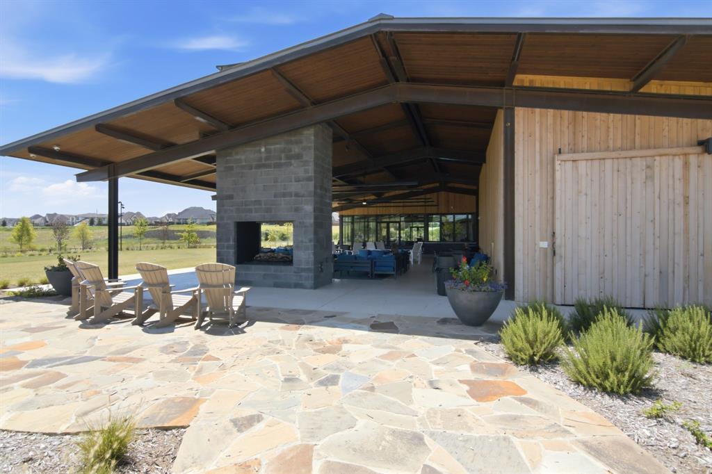 201 Pintail Lane Rhome, TX 76078 - Photo 34 of 36 Expansive outdoor living area featuring a stone flagstone patio, a large covered porch with a wood-finish ceiling, and an integrated stone-block fireplace