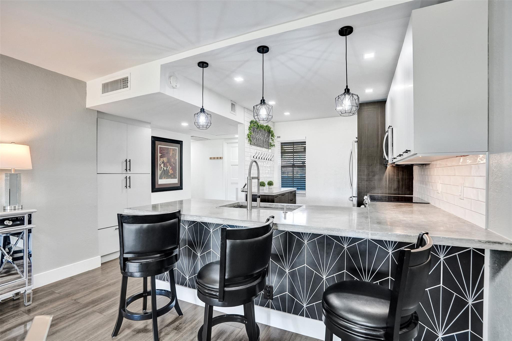 3001 South Course Drive, Unit 107 Pompano Beach, FL 33069 - Photo 18 of 47 a kitchen with a dining table chairs stainless steel appliances and cabinets