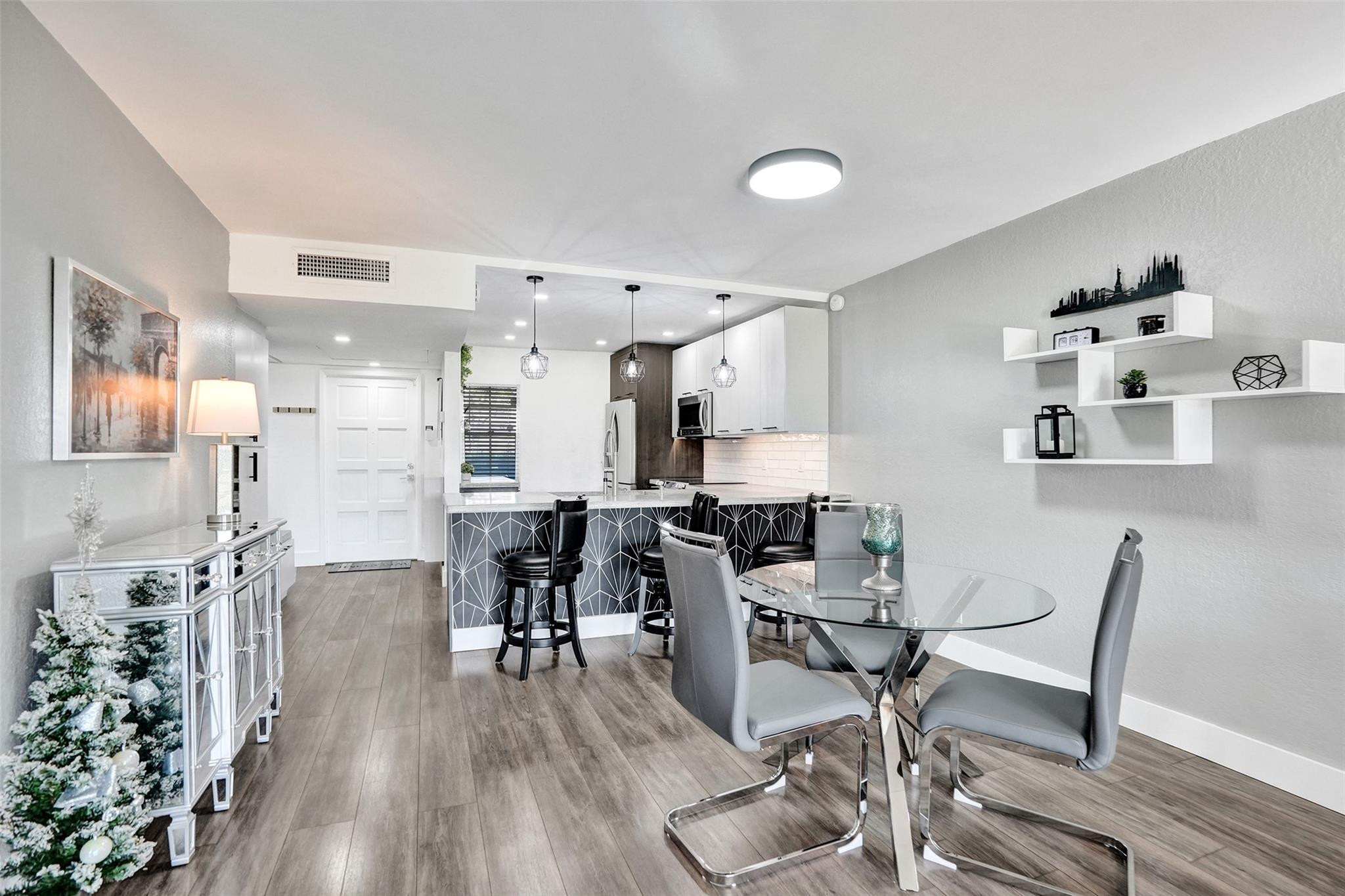 3001 South Course Drive, Unit 107 Pompano Beach, FL 33069 - Photo 23 of 47 a view of a dining room with furniture and wooden floor