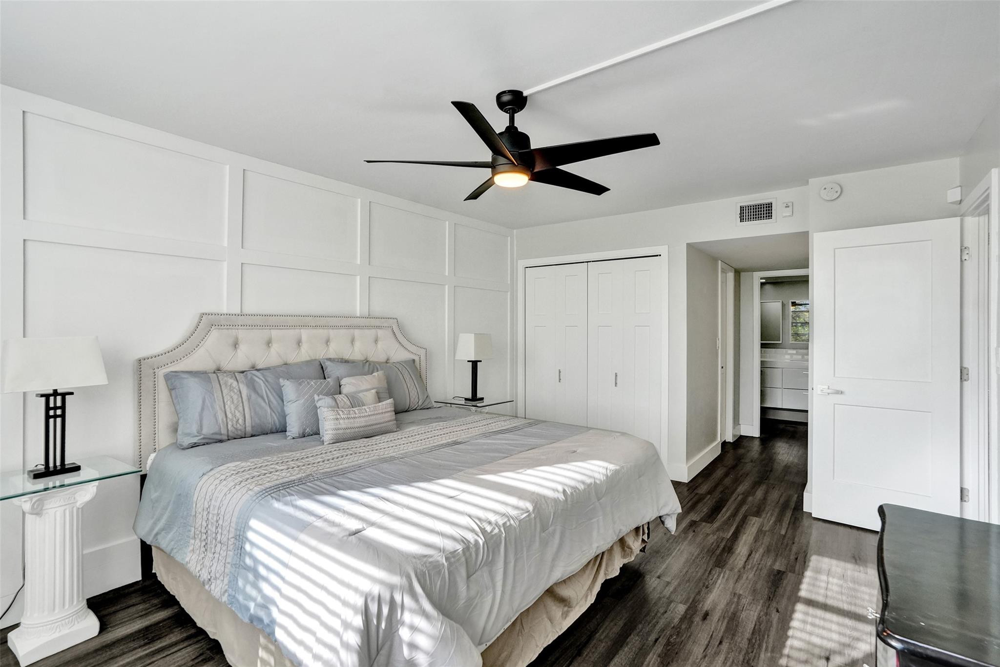 3001 South Course Drive, Unit 107 Pompano Beach, FL 33069 - Photo 27 of 47 a bedroom with a bed and a chandelier