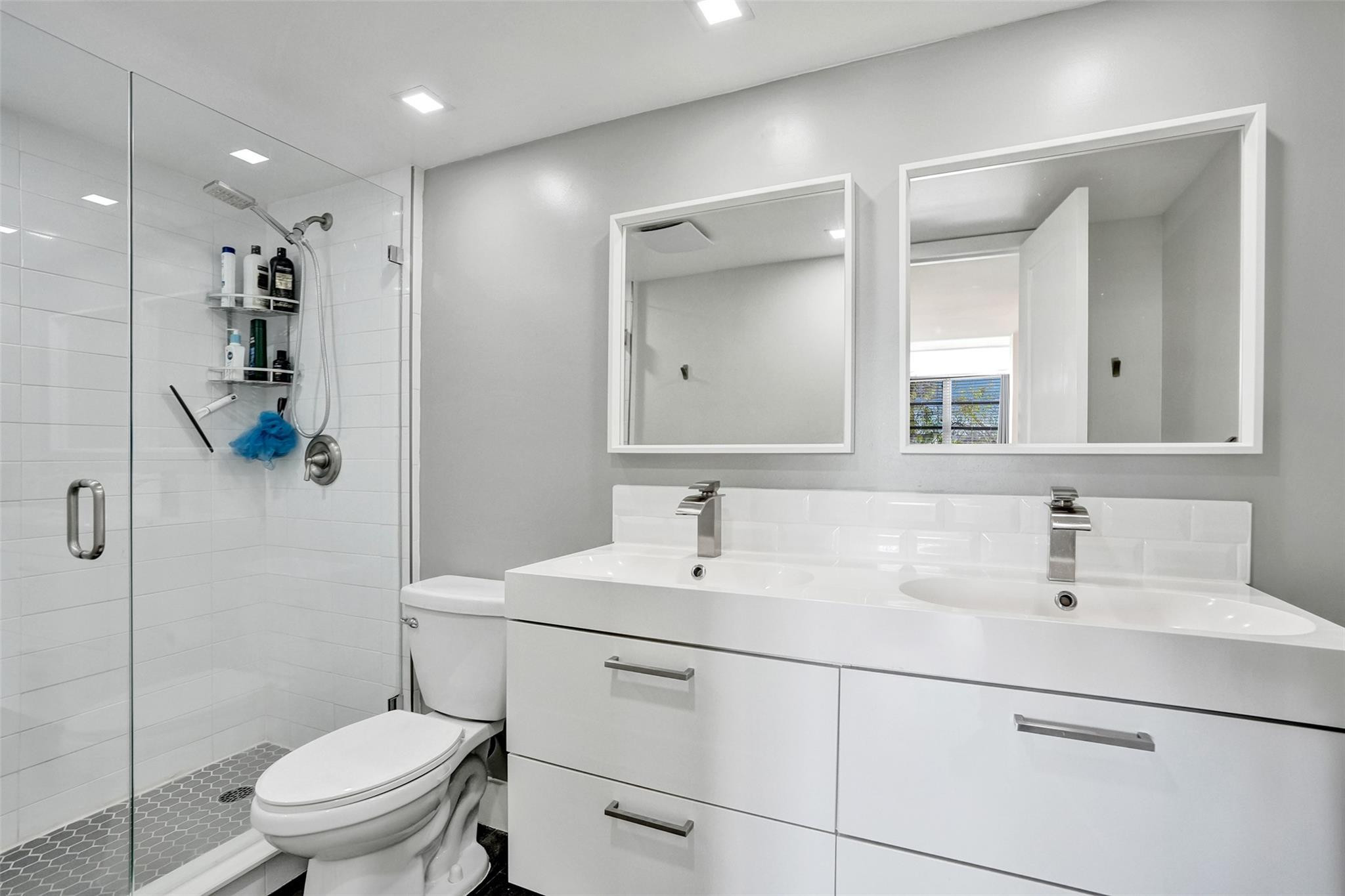 3001 South Course Drive, Unit 107 Pompano Beach, FL 33069 - Photo 31 of 47 a bathroom with a toilet sink shower and mirror