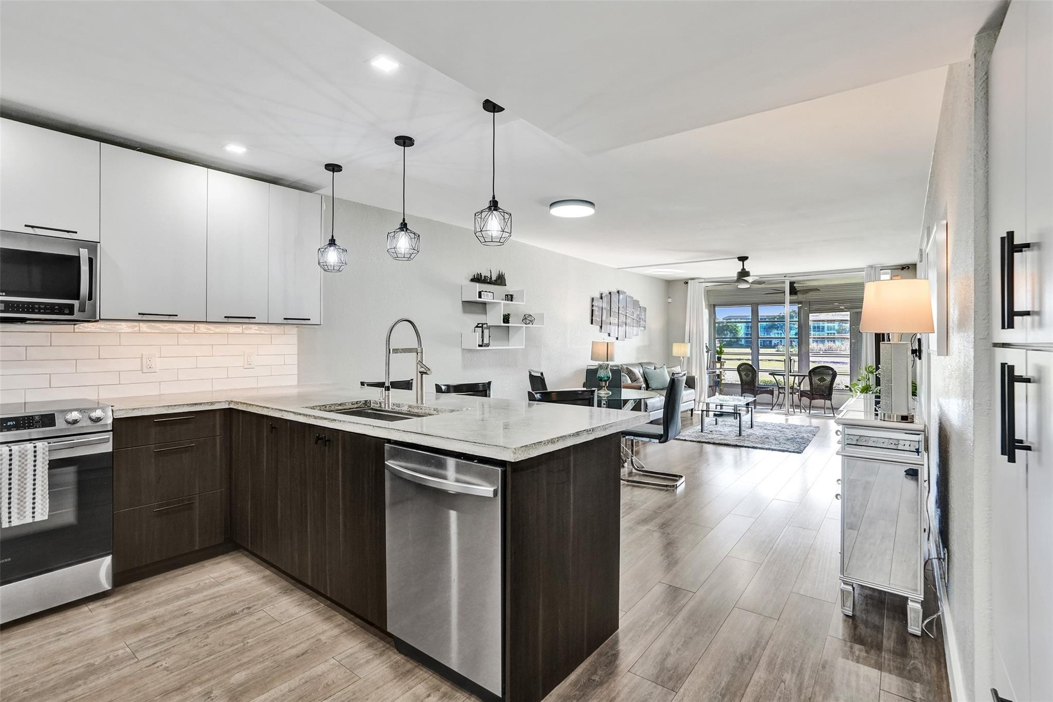 3001 South Course Drive, Unit 107 Pompano Beach, FL 33069 - Photo 5 of 47 a kitchen with stainless steel appliances granite countertop a sink stove and wooden floor