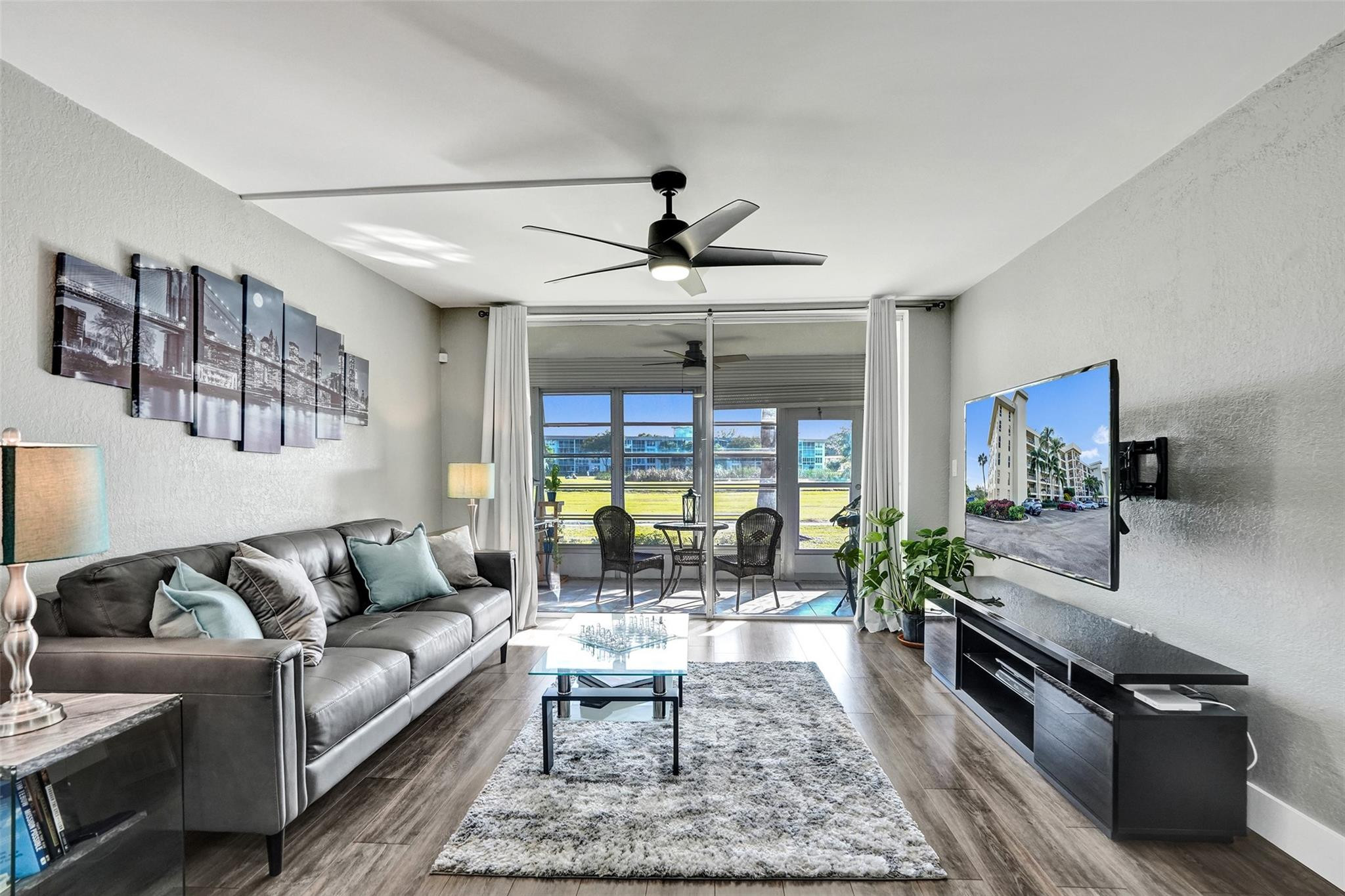 3001 South Course Drive, Unit 107 Pompano Beach, FL 33069 - Photo 6 of 47 a living room with furniture and a flat screen tv