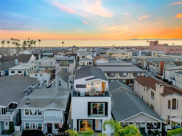 an aerial view of ocean and residential houses with outdoor space