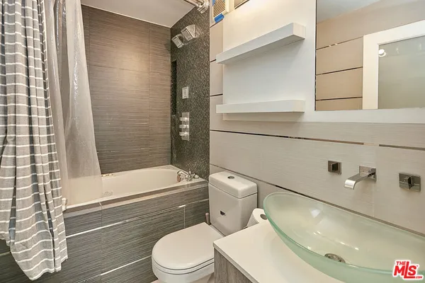 a white toilet sitting next to a bath tub and shower