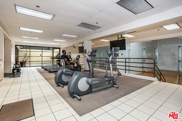 a room with gym equipment and view of living room