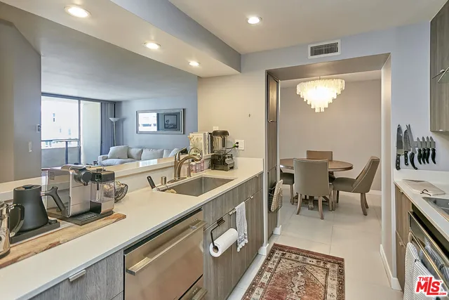 a very nice looking dining room with kitchen island a large window and stainless steel appliances