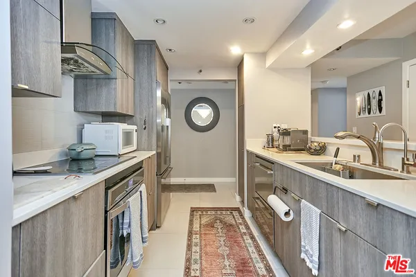 a kitchen with granite countertop a sink a stove and cabinets