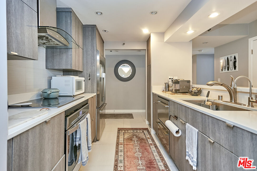 600 West 9th Street, Unit 805 Los Angeles, CA 90015 - Photo 6 of 28 a kitchen with granite countertop a sink a stove and cabinets