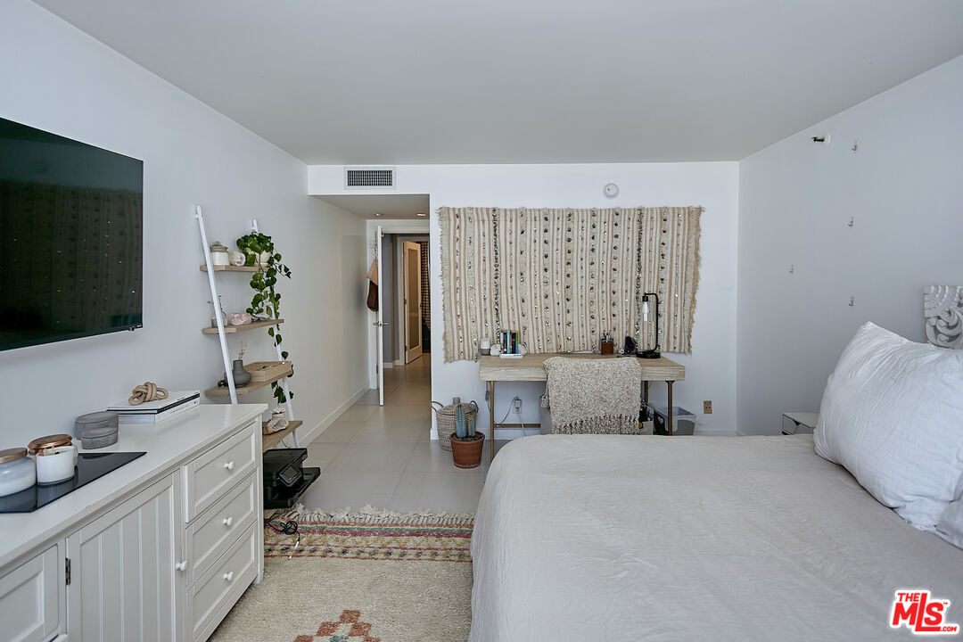 600 West 9th Street, Unit 805 Los Angeles, CA 90015 - Photo 9 of 28 a bedroom with a large bed and a flat tv screen on dresser