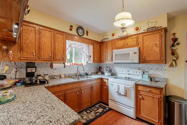 a kitchen with stainless steel appliances granite countertop a sink a stove cabinets and a refrigerator