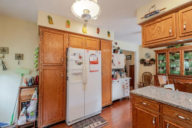 a bathroom with a sink a refrigerator and a mirror