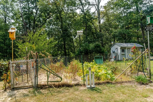 a view of a house with a backyard and trees