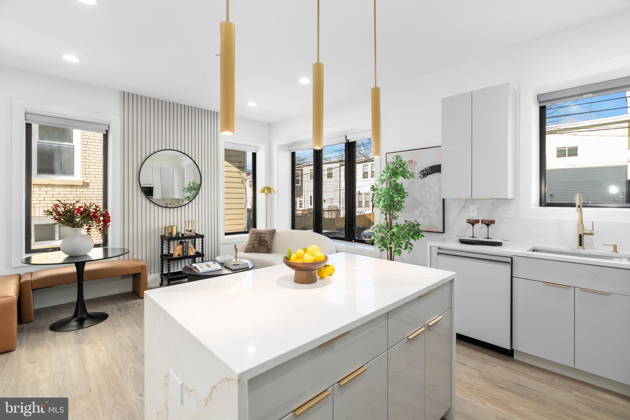 a kitchen with a sink dishwasher a dining table chairs and a clock