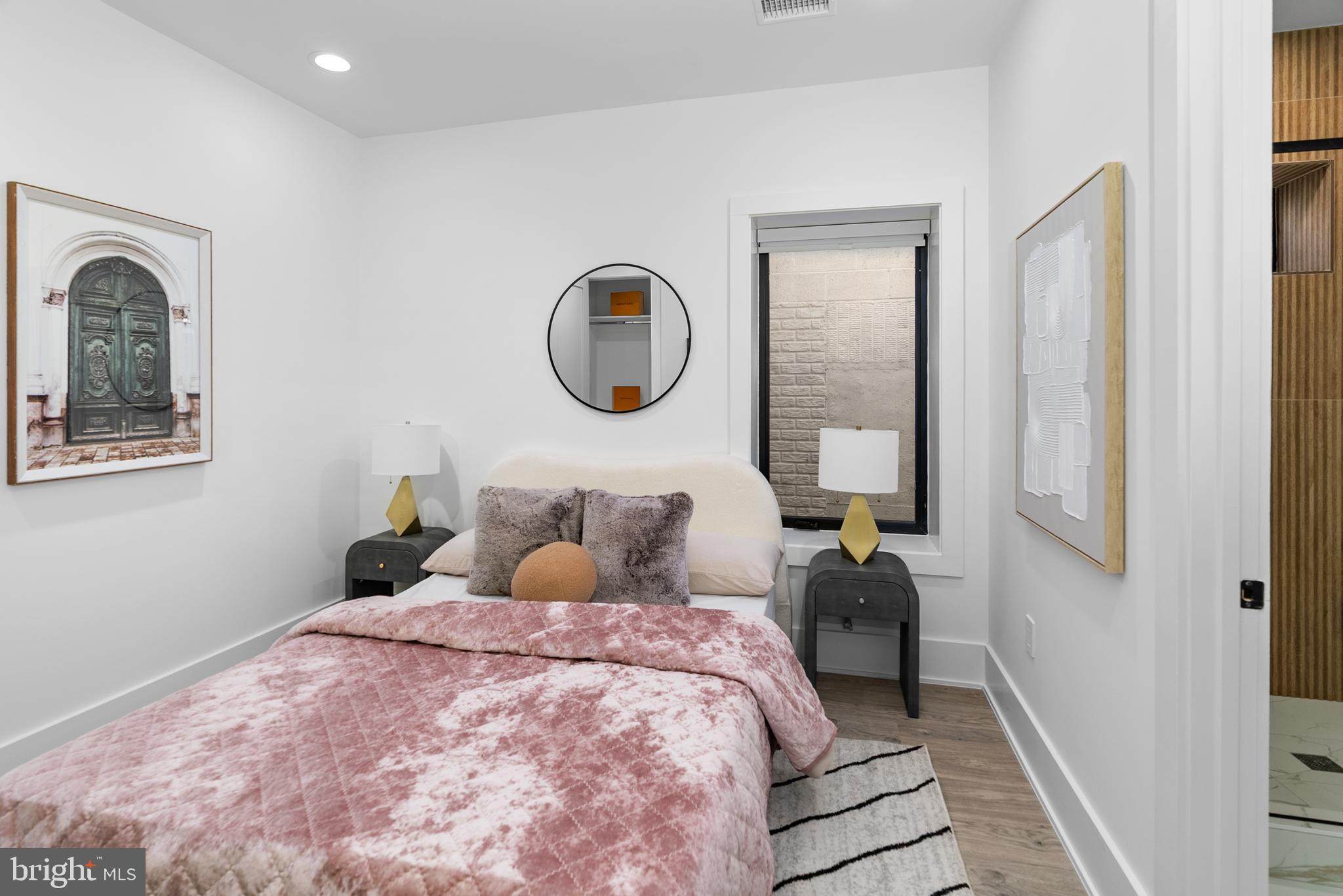 1140 Oates Street Northeast, Unit 101 Washington, DC 20002 - Photo 19 of 34 a bedroom with a large bed and a chandelier