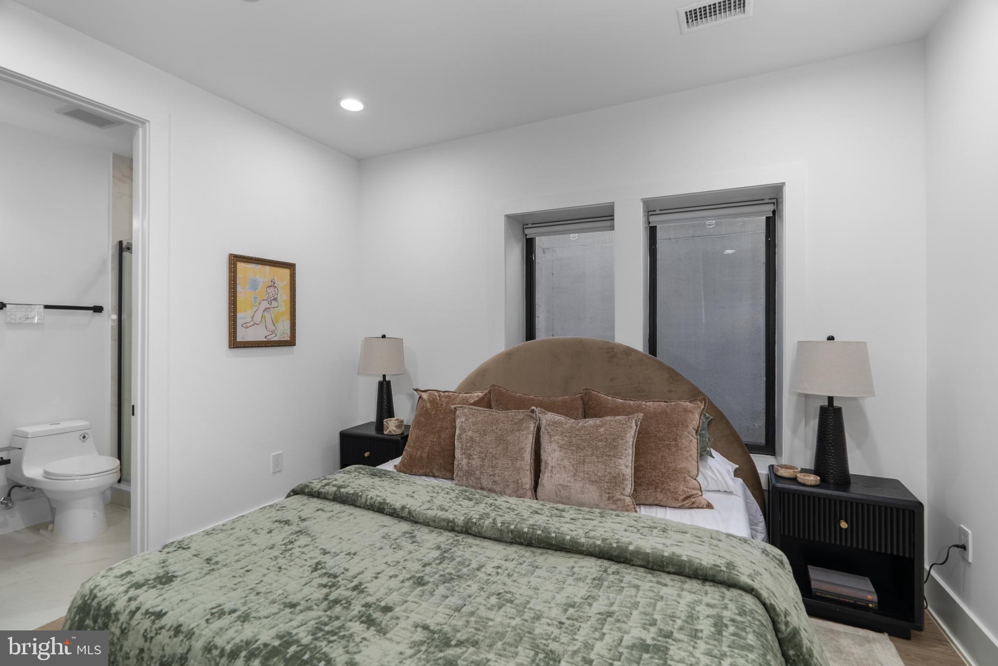 1140 Oates Street Northeast, Unit 101 Washington, DC 20002 - Photo 26 of 34 a bedroom with a bed and a lamp on dresser