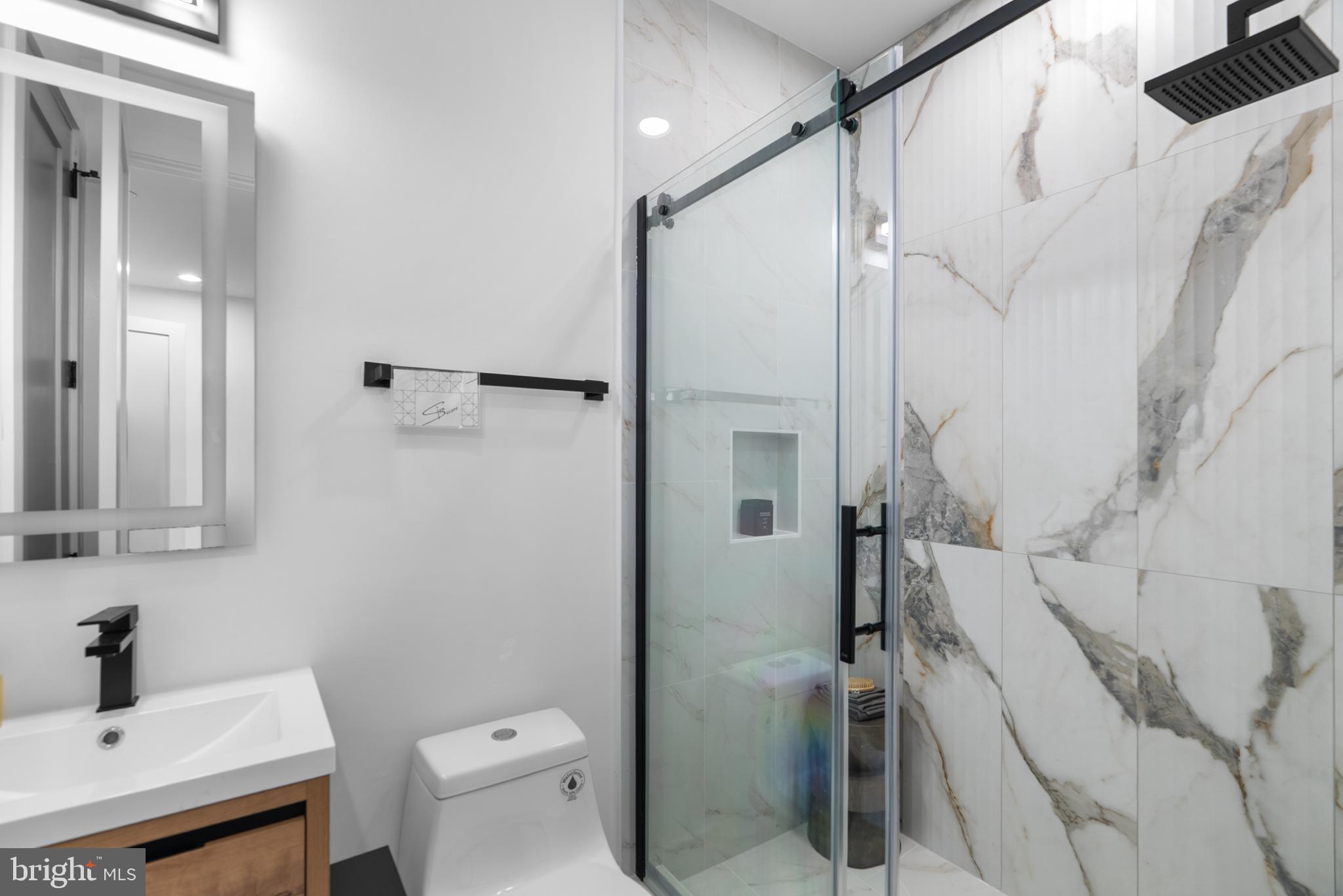 1140 Oates Street Northeast, Unit 101 Washington, DC 20002 - Photo 27 of 34 a bathroom with a sink a toilet and shower
